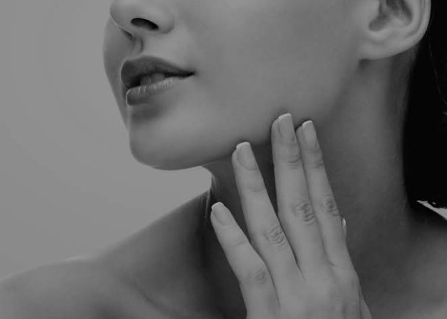 Retrato en blanco y negro de una mujer con la mano apoyada en el cuello
