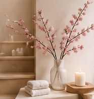 Rincón decorativo con flores rosas, toallas y vela